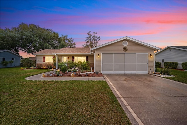 single story home with concrete driveway, a lawn, and an attached garage