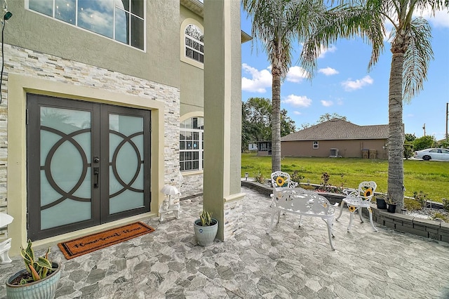 54 Andora Ct, Kissimmee, FL 34758 - doorway to property featuring stucco siding, french doors, stone siding, a patio area, and a lawn