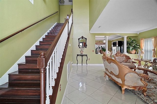 54 Andora Ct, Kissimmee, FL 34758 - stairway with baseboards, tile patterned flooring, visible vents, ornate columns, and arched walkways