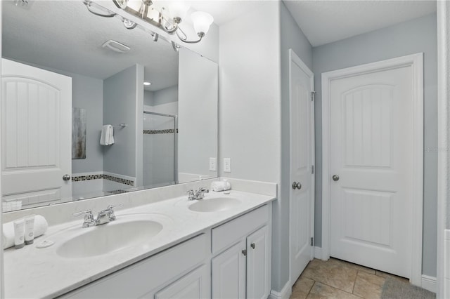 full bath with a shower stall, double vanity, baseboards, and a sink