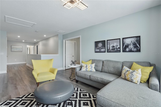 living area with recessed lighting, baseboards, attic access, and wood finished floors
