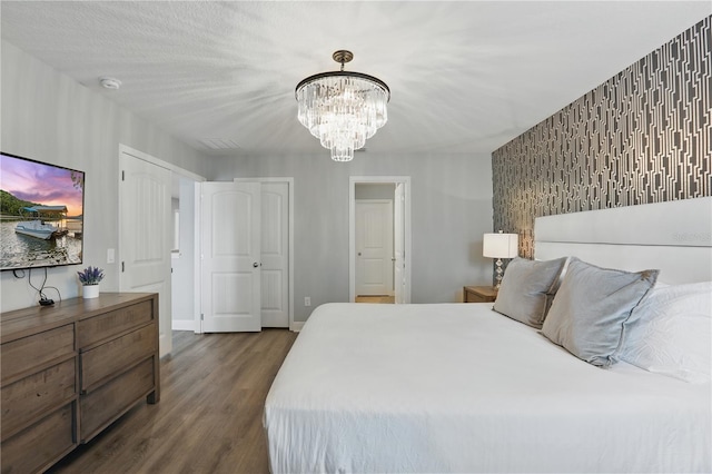 bedroom with visible vents, baseboards, a notable chandelier, and dark wood-style floors
