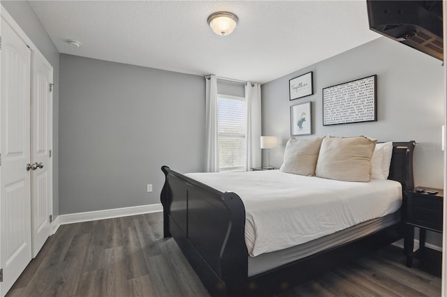 bedroom featuring dark wood-type flooring and baseboards