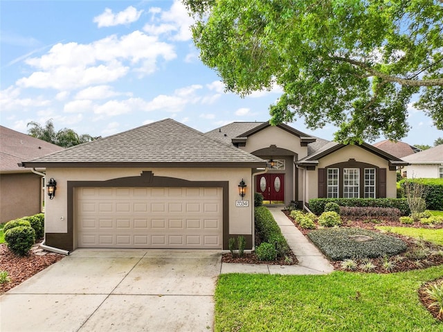 view of front of house featuring a shingled roof, a garage, driveway, and stucco siding