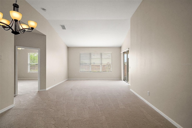 unfurnished room with baseboards, vaulted ceiling, an inviting chandelier, light carpet, and visible vents