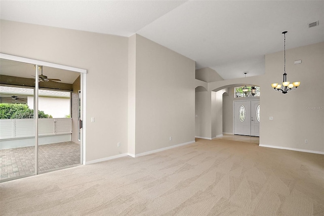 unfurnished living room with arched walkways, visible vents, light colored carpet, and baseboards