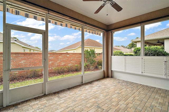 unfurnished sunroom with a ceiling fan and plenty of natural light