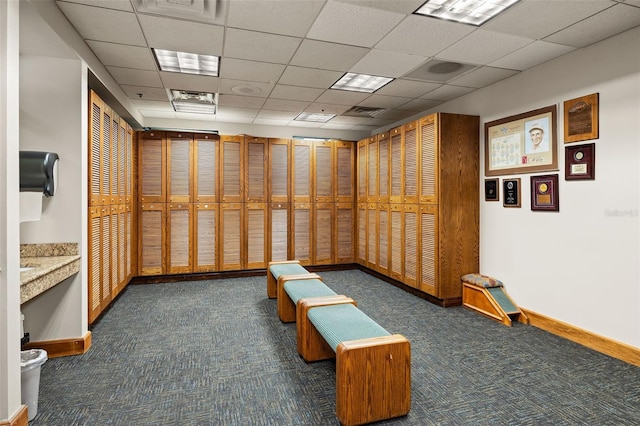 interior space featuring visible vents, baseboards, a drop ceiling, and carpet