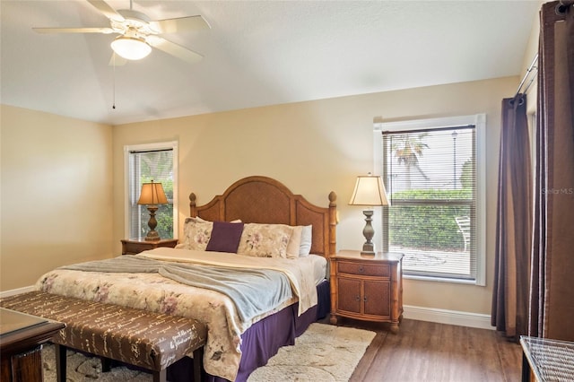 bedroom with baseboards, dark wood-style flooring, and ceiling fan