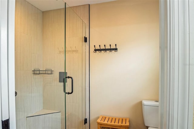 full bath featuring a stall shower and toilet