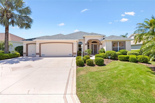 view of front of house featuring a garage, stucco siding, concrete driveway, and a front lawn