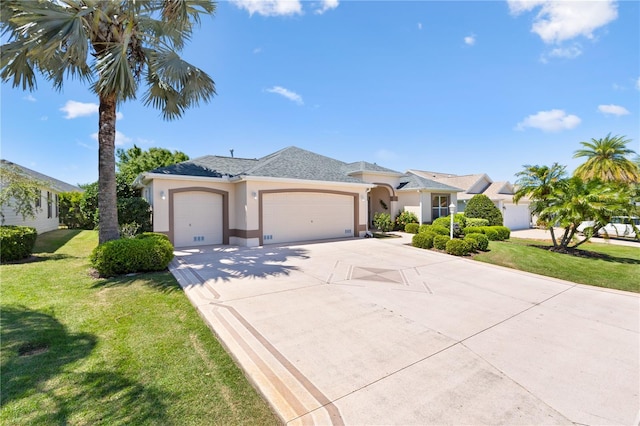 view of front of house featuring concrete driveway, an attached garage, a front lawn, and stucco siding