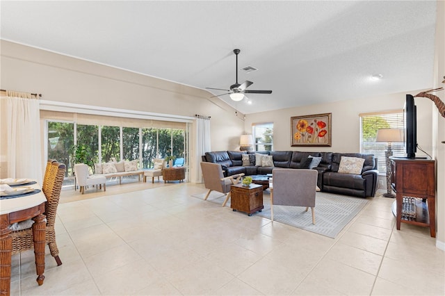 living area with a wealth of natural light, visible vents, ceiling fan, and lofted ceiling