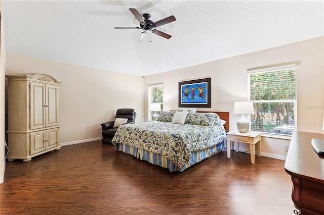 bedroom with a textured ceiling, wood finished floors, baseboards, and multiple windows