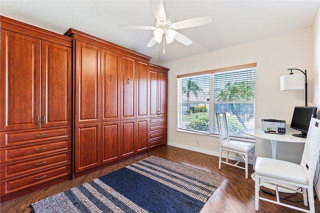 office featuring dark wood-type flooring, ceiling fan, and baseboards