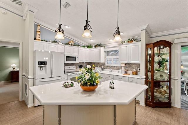 1526 Blueberry Way, The Villages, FL 32162 - kitchen with decorative backsplash, ornamental molding, white appliances, and visible vents