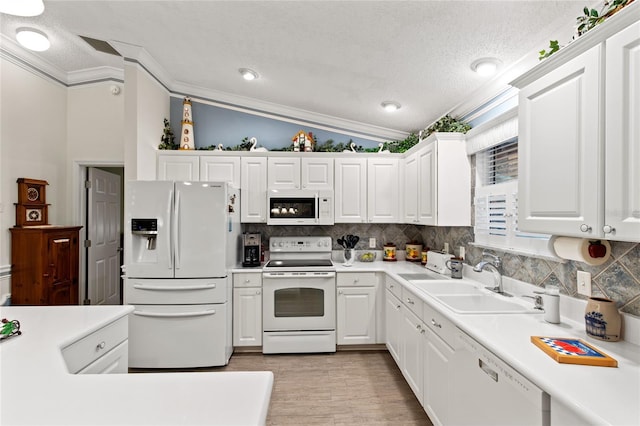 1526 Blueberry Way, The Villages, FL 32162 - kitchen with white cabinets, white appliances, a sink, and crown molding