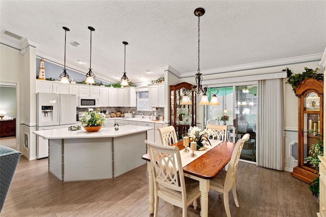 1526 Blueberry Way, The Villages, FL 32162 - dining room with a textured ceiling, ornamental molding, visible vents, and light wood-style floors