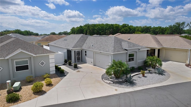 ranch-style home featuring an attached garage, fence, driveway, and stucco siding