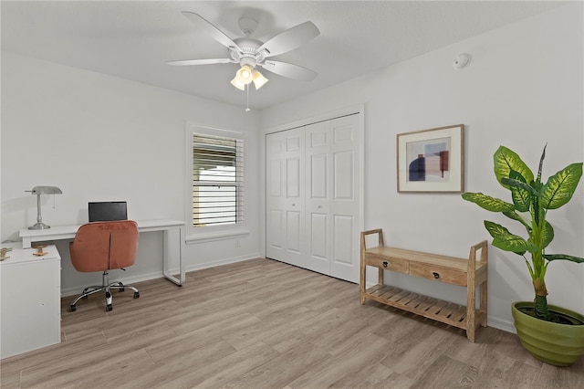 office space with light wood-style floors, baseboards, and a ceiling fan