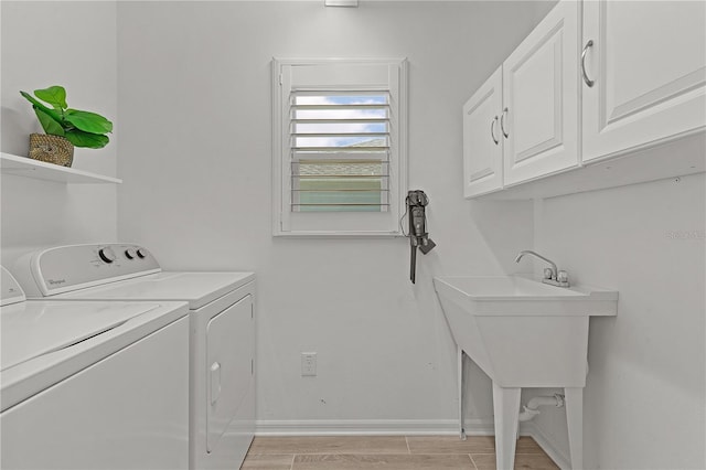 clothes washing area featuring cabinet space, baseboards, light wood-style floors, and independent washer and dryer