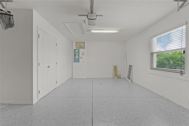 garage featuring electric panel, a garage door opener, and concrete block wall