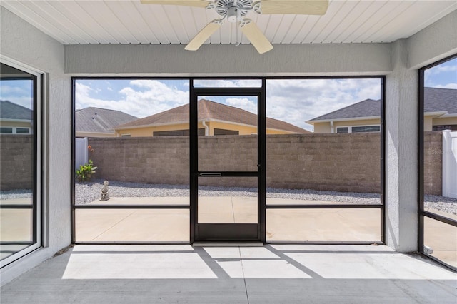 unfurnished sunroom featuring a ceiling fan