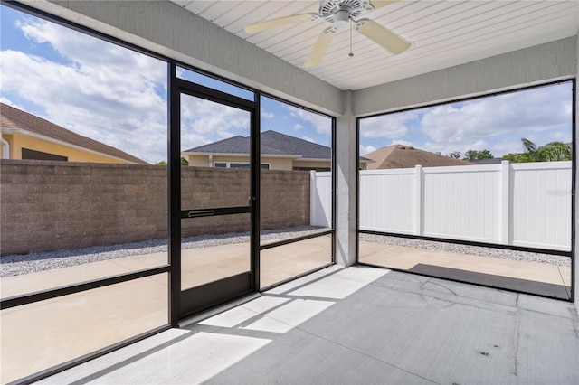 unfurnished sunroom with ceiling fan