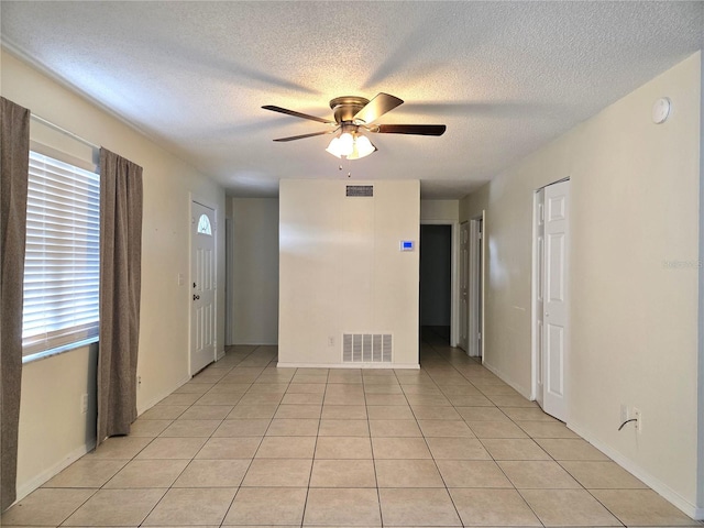 spare room featuring visible vents, a ceiling fan, and a textured ceiling