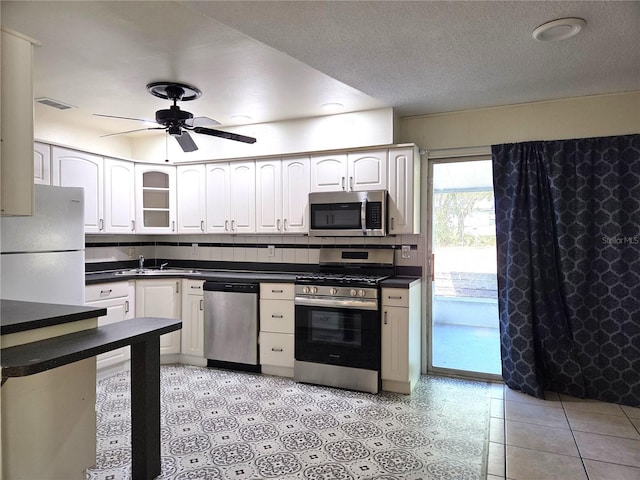 kitchen with stainless steel appliances, visible vents, ceiling fan, and dark countertops