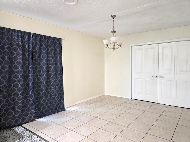 unfurnished dining area featuring light tile patterned floors, a chandelier, and a textured ceiling