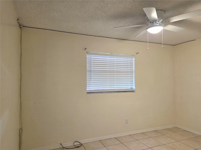 unfurnished room with baseboards, light tile patterned floors, a textured ceiling, and a ceiling fan