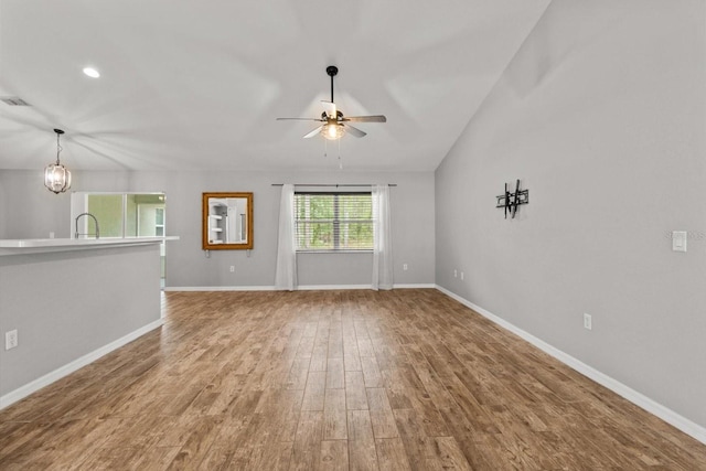 17 Eugenia Ct N, Homosassa, FL 34446 - unfurnished living room with ceiling fan with notable chandelier, recessed lighting, wood finished floors, a sink, and baseboards