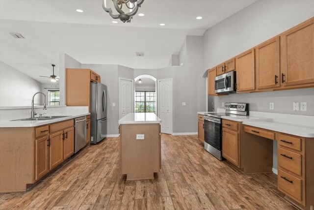 17 Eugenia Ct N, Homosassa, FL 34446 - kitchen featuring vaulted ceiling, a kitchen island, appliances with stainless steel finishes, arched walkways, and a sink