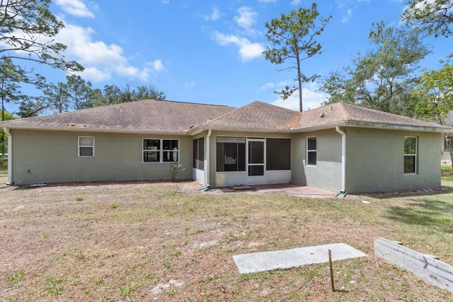 17 Eugenia Ct N, Homosassa, FL 34446 - rear view of property with a sunroom, a shingled roof, stucco siding, and a lawn