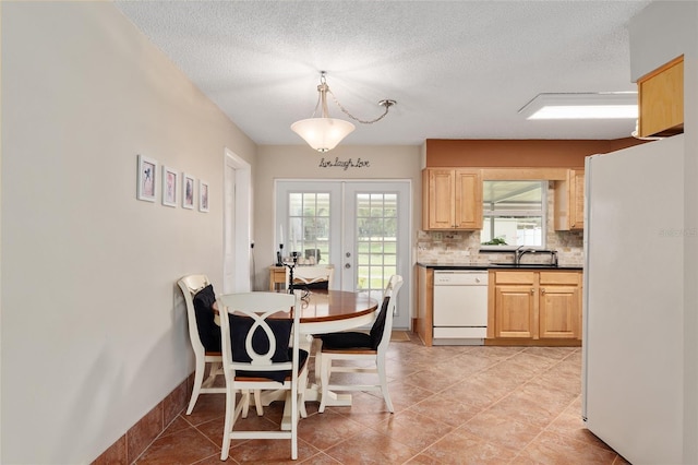 dining room featuring french doors, a wealth of natural light, light tile patterned floors, and a textured ceiling