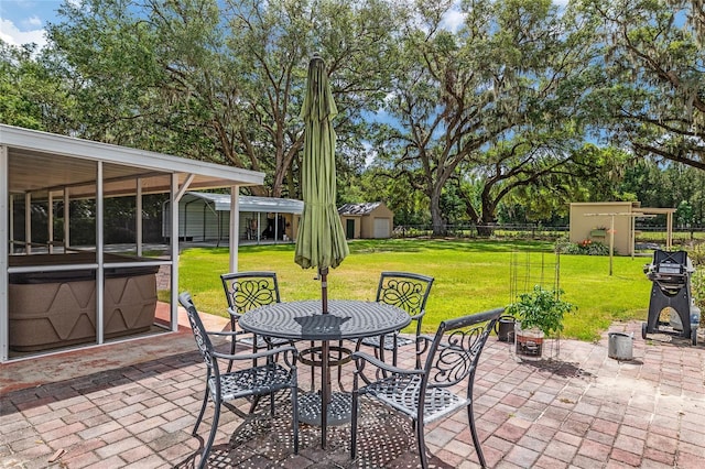 view of patio / terrace with an outbuilding, outdoor dining space, fence, and a storage unit