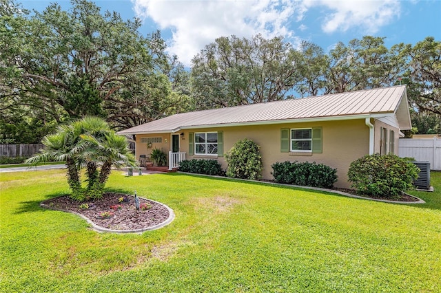 single story home with a front yard, metal roof, stucco siding, and fence