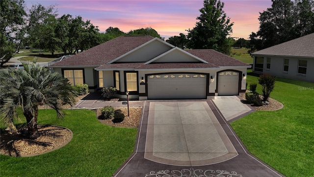 view of front of home featuring concrete driveway, roof with shingles, stucco siding, a front lawn, and an attached garage