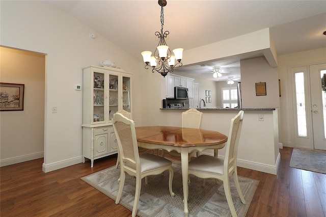 dining room featuring dark wood-style flooring, baseboards, and ceiling fan with notable chandelier