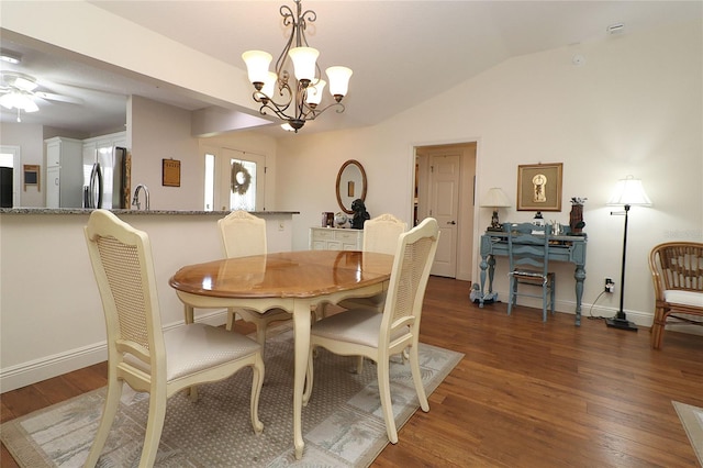 dining area with wood finished floors, ceiling fan with notable chandelier, baseboards, and lofted ceiling