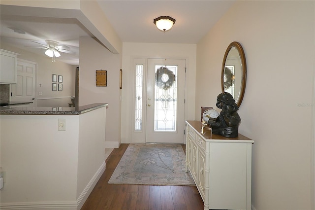 foyer featuring dark wood finished floors, baseboards, and a ceiling fan