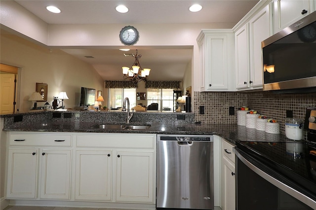 kitchen featuring dark stone countertops, white cabinetry, a sink, and appliances with stainless steel finishes