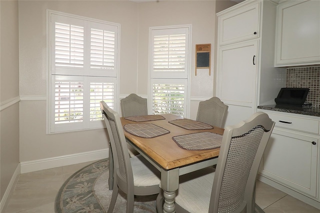 dining area featuring light tile patterned flooring, baseboards, and plenty of natural light