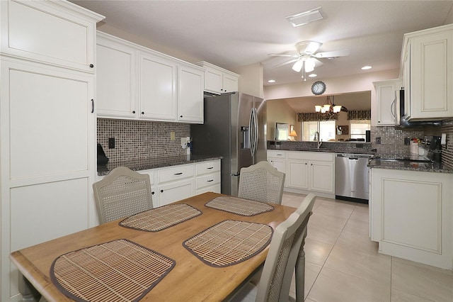 kitchen featuring tasteful backsplash, appliances with stainless steel finishes, ceiling fan with notable chandelier, and visible vents