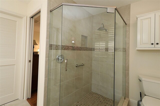 full bath featuring a shower stall and toilet