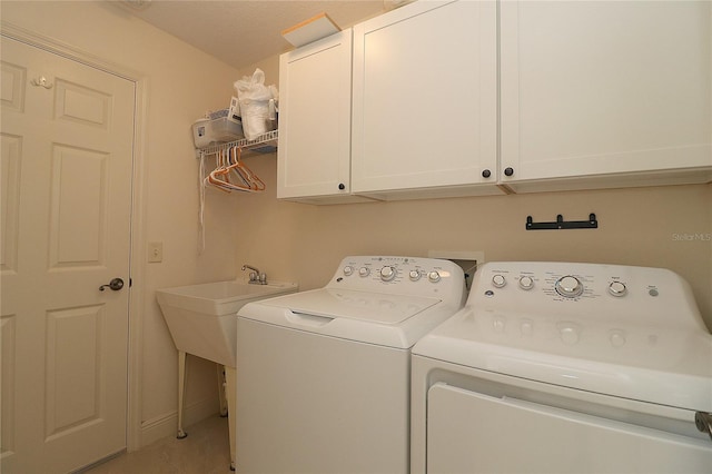 laundry area featuring separate washer and dryer, tile patterned flooring, and cabinet space