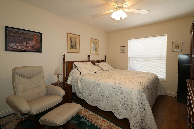 bedroom featuring ceiling fan, baseboards, and dark wood finished floors