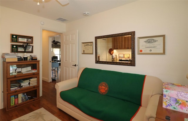 living area with visible vents, ceiling fan, and wood finished floors