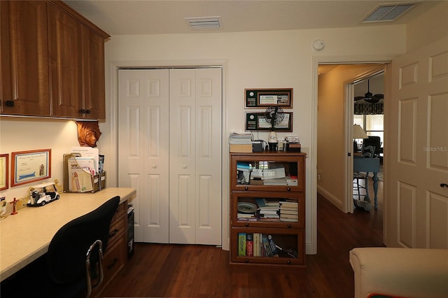 office area with built in desk, dark wood-style flooring, and visible vents
